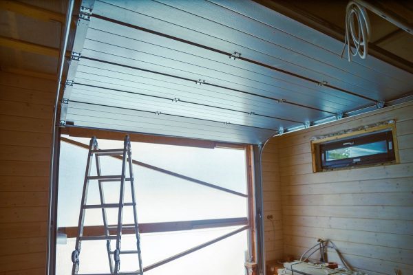 Interior view of a garage door installation with ladder and ceiling track system